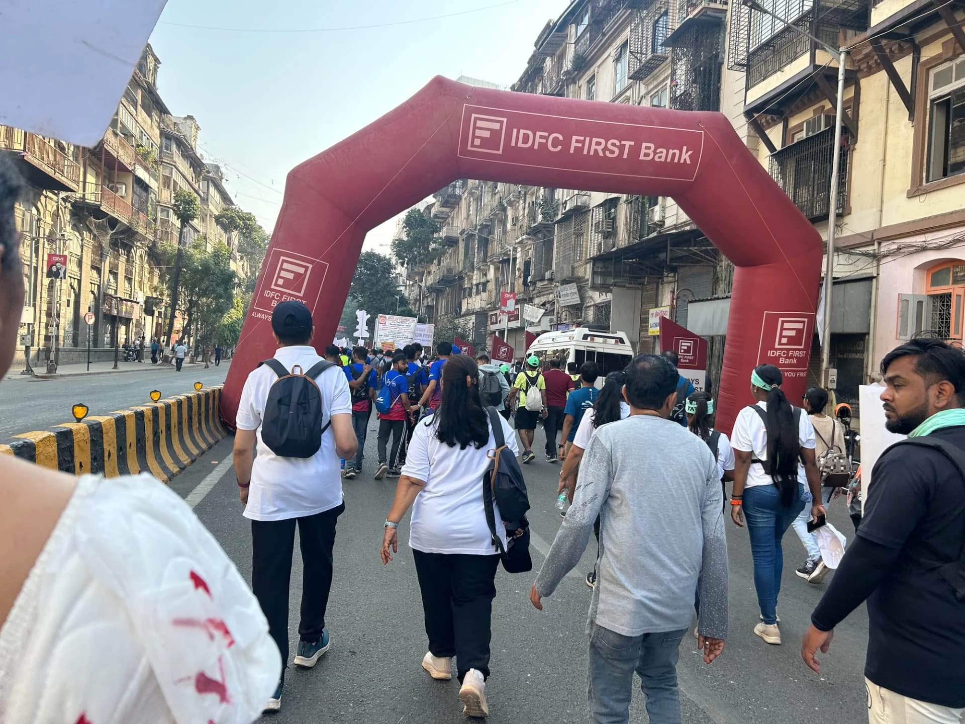 Participants passing under the finish arch on a heritage Mumbai street